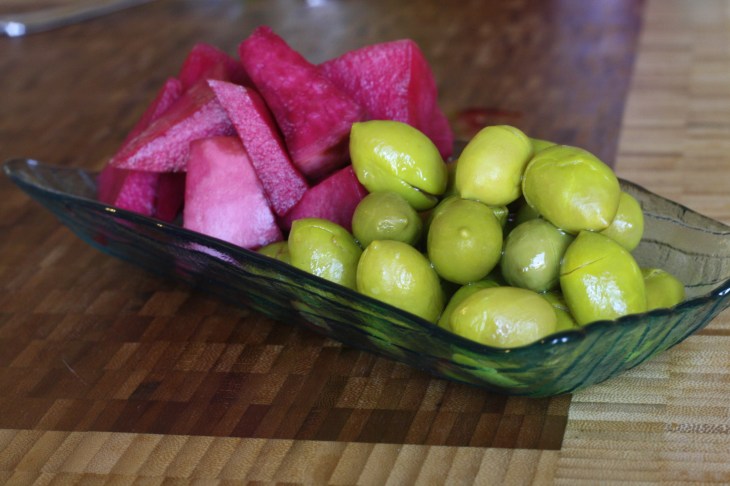 While everything simmers and comes together, plate some complementary side dishes. Here we have tangy green olives and pickled turnips. 